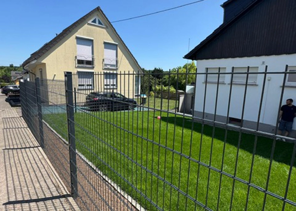 Verlegter Rollrasen mit Zaun davor